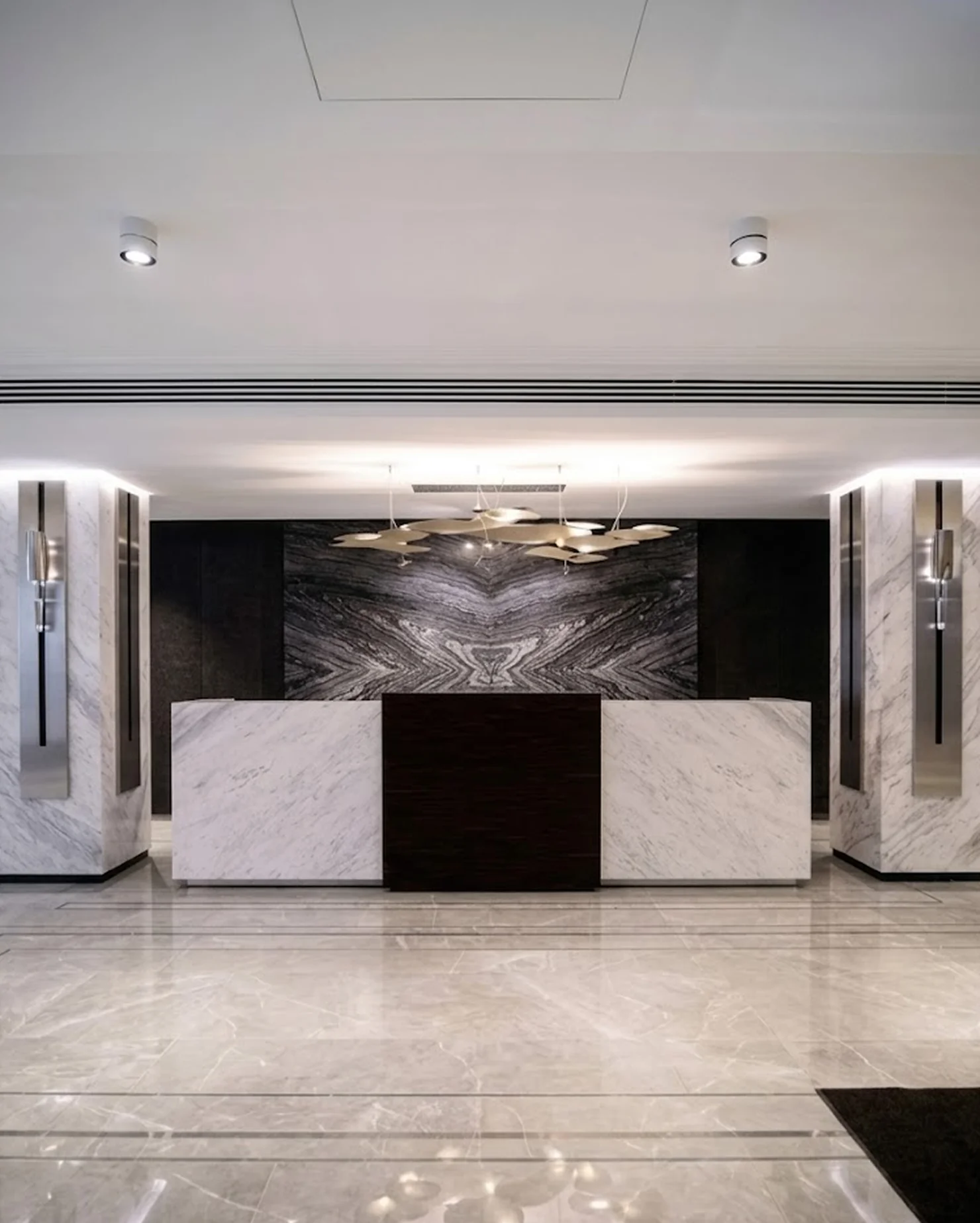 Ресепшен с Bookmatch-панно из мрамора Silver Wave и Volakas